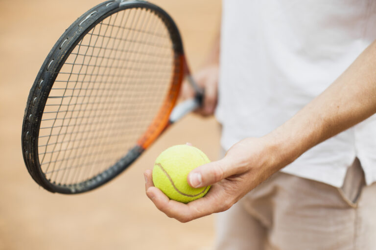 man-holding-tennis-ball-racket